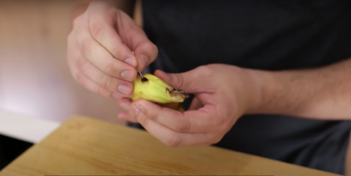 Han prikker huller i en banan: Se så hvad der sker