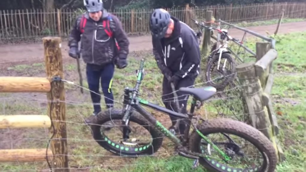 Hylemorsomt: Fire mænd forsøger at få en cykel fri fra et elektrisk hegn