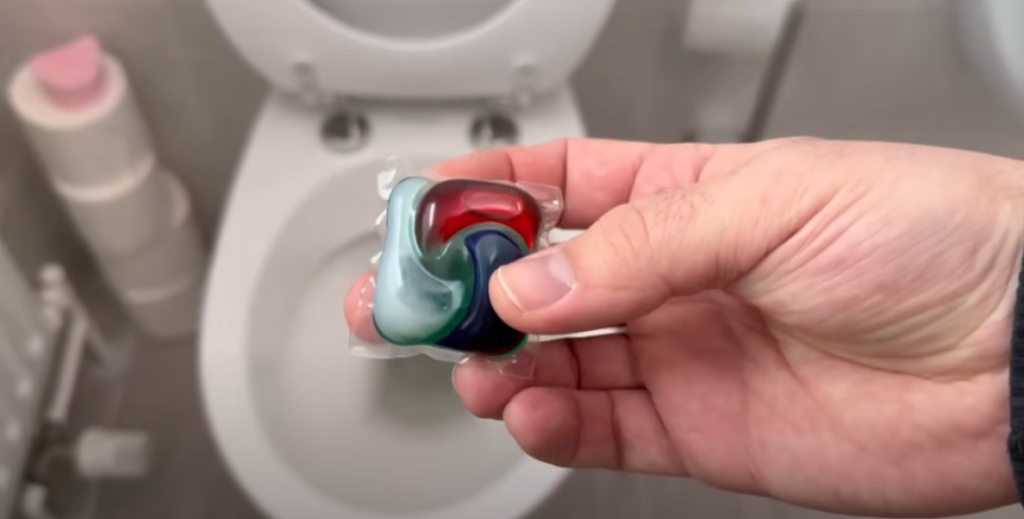 Han smider en vaskekapsel i toilettet. Se så magien ske.