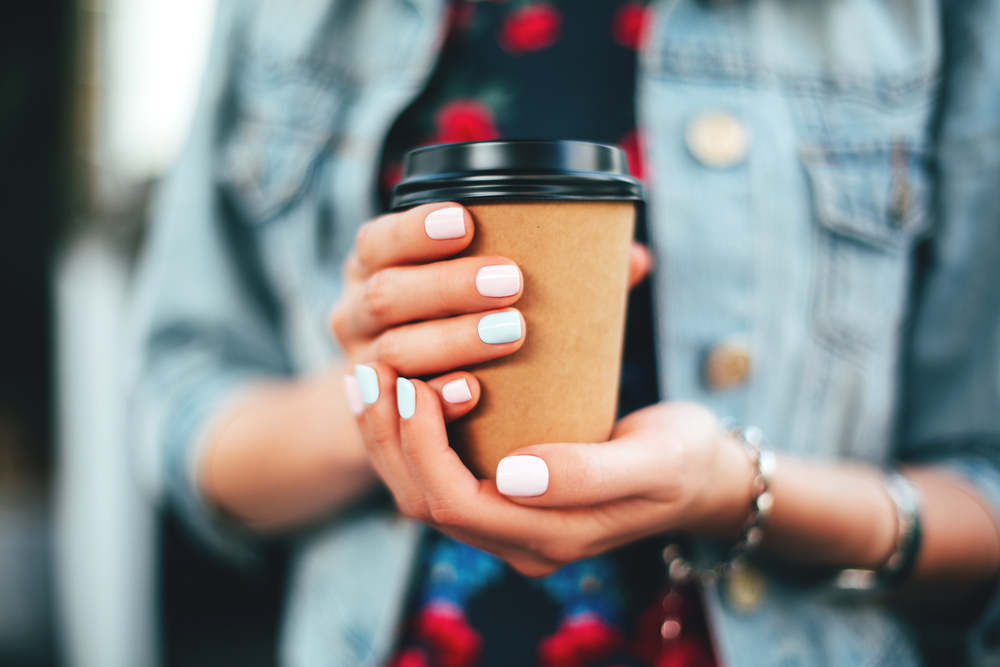 Kvinde med kaffe to go krus